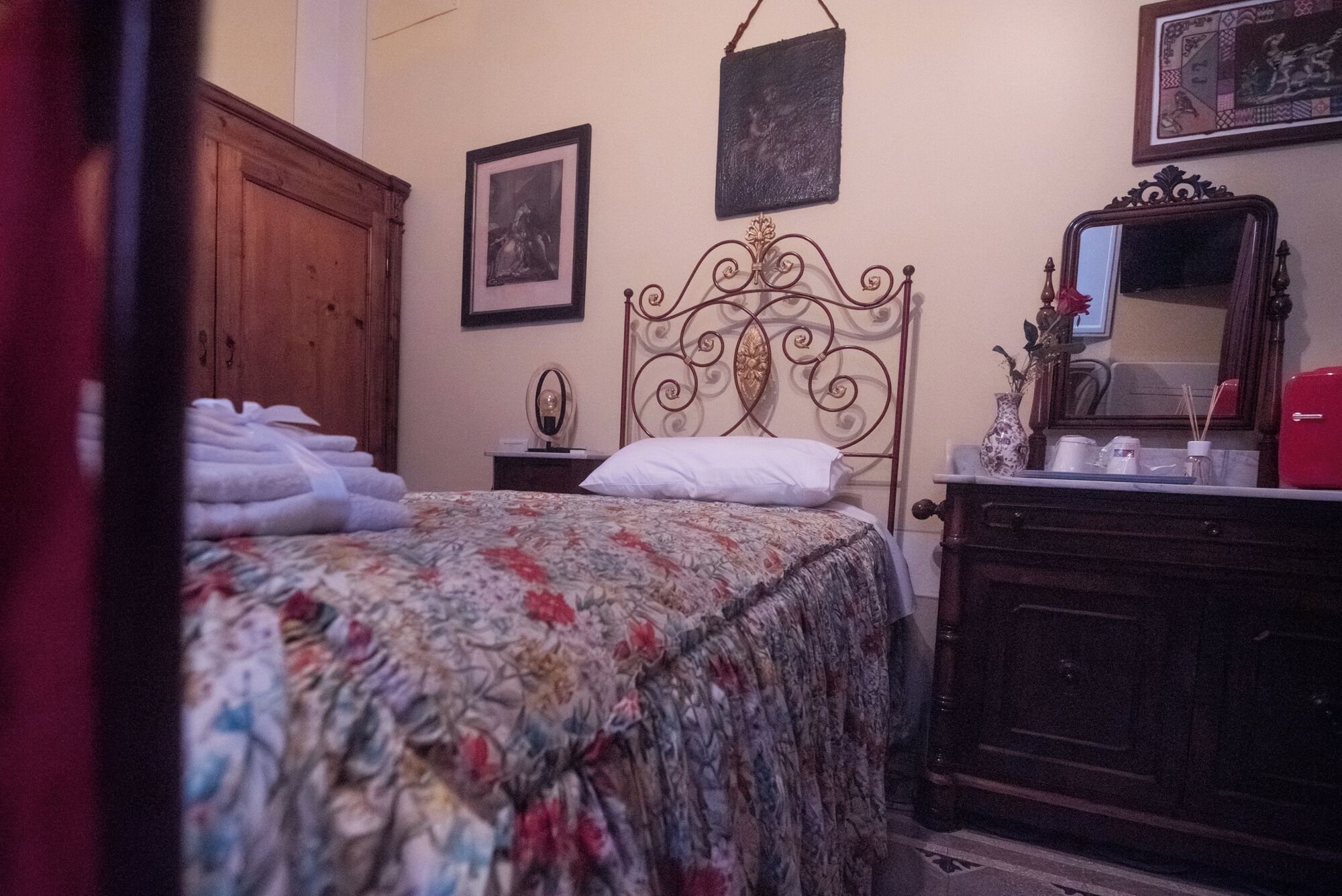 Un dormitorio con cama, cómoda, espejo y un cuadro en la pared.