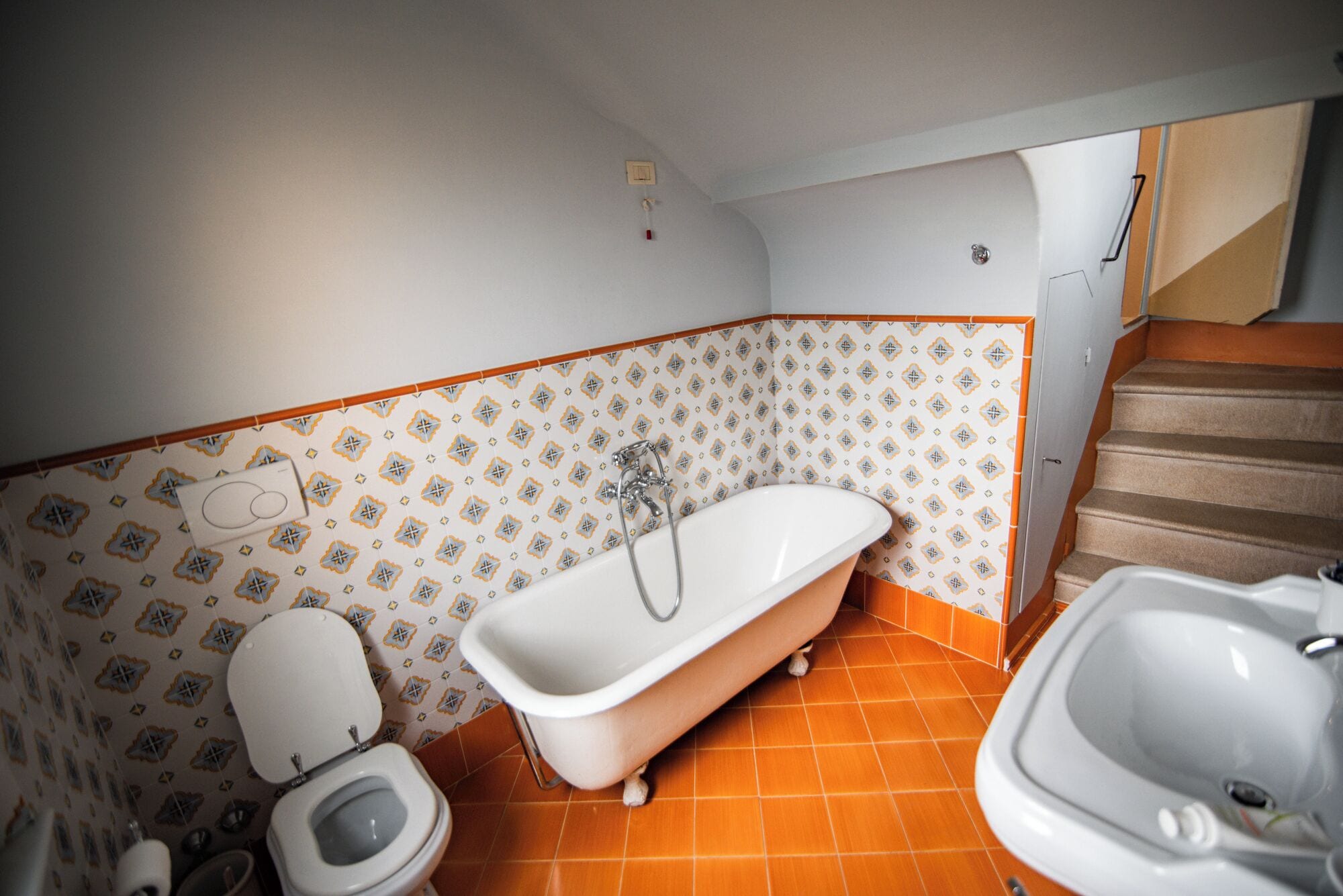 Une salle de bain comprenant des toilettes, une baignoire à l’ancienne et un espace douche séparé.