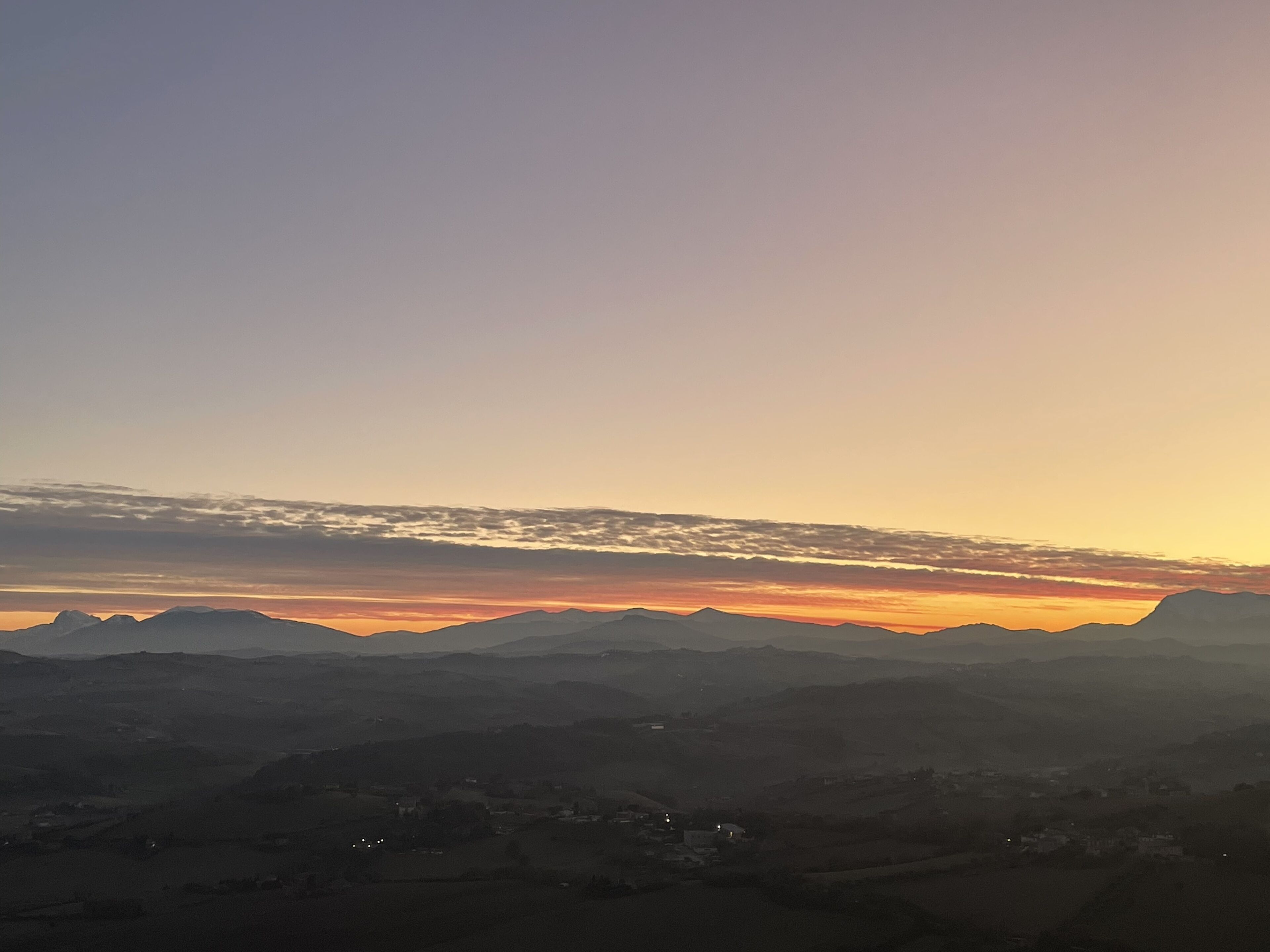 A panoramic view of a mountainous landscape during sunset.