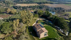 An aerial view of a rural property with a stone house, a swimming pool, and solar panels. - Villa Dada 10 Emma Villas (Rosignano Marittimo)