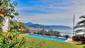 Una piscina con vistas a una ciudad y montañas al fondo.