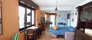 Ein Zimmer mit Bett, Schreibtisch, Stuhl und Essecke.