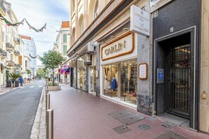A street view with a storefront named 'CARLIN' and a building with a sign 'CORNELIANI'.