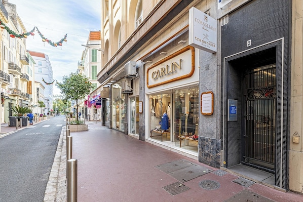 A street view with a storefront named 'CARLIN' and a building with a sign 'CORNELIANI'.