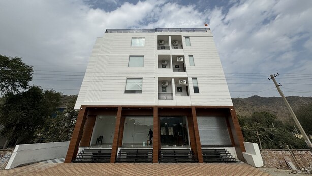 Un edificio moderno a più piani con ampie finestre e condizionatori.