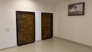 Un corridoio con due porte in legno e un quadro appeso al muro.