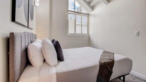A bedroom with a bed, a window, and a ceiling light. - TWO CozySuites Apt w Skybridge Access 4 (Indianapolis)
