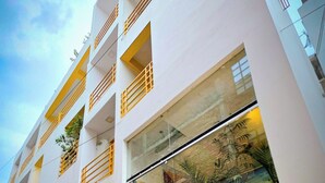 A modern building with multiple balconies and a glass storefront. - The White Canyon (Varanasi)
