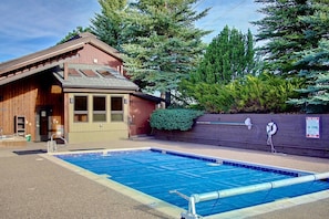 A wooden building with a pool, a lifeguard stand, and a no diving sign.