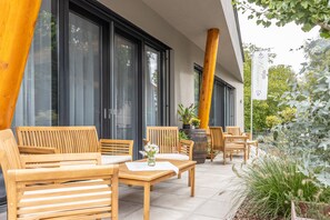 Un área de estar al aire libre con muebles de madera y una planta en maceta.