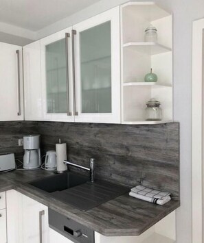 Een koelkast, een kookplaat, eettafels