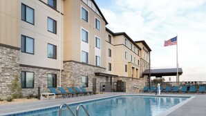 A hotel with a swimming pool, lounge chairs, and an American flag. - Hampton Inn & Suites Porter Ranch Los Angeles (Porter Ranch)