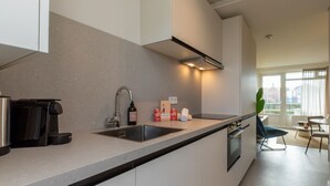 Une cuisine moderne équipée d’une cuisinière intégrée, d’un évier et d’une machine à café.