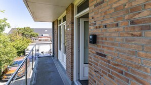 Un edificio de ladrillo con balcón, puerta y buzón.