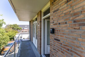 A brick building with a balcony, a door, and a mailbox. - Zoutelande Retreat by Sea (Zoutelande)
