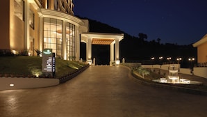 L’entrée d’un hôtel de nuit, avec un chemin bien éclairé menant à une zone abritée.