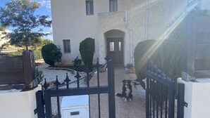 A gated entrance to a building with a tiled pathway leading to a door. - Villa Ariadni - Luxurious Villa with Spectacular Views and Private Pool! (Pissouri)