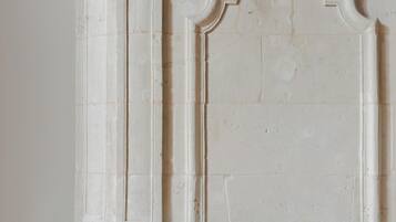 A white fireplace with intricate carvings and a simple, clean design.