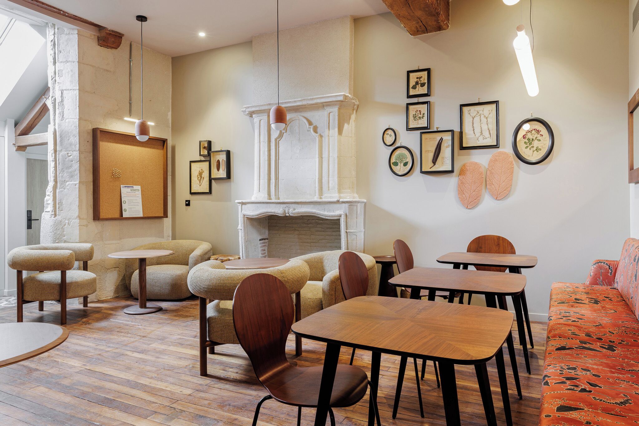 A cozy interior with a fireplace, wooden furniture, and framed artwork on the walls.
