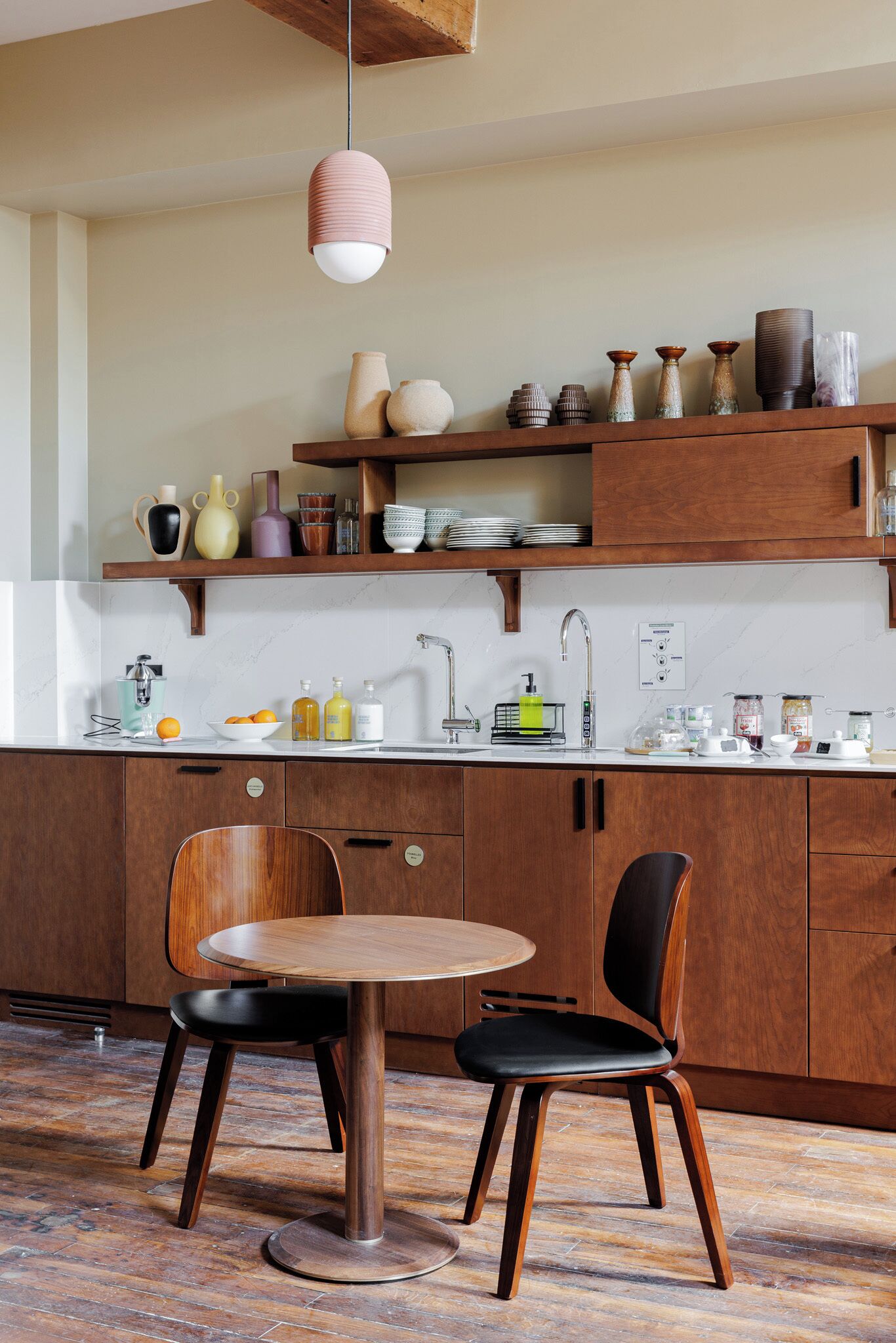 Una cocina moderna con armarios de madera, una mesa redonda de comedor y dos sillas.