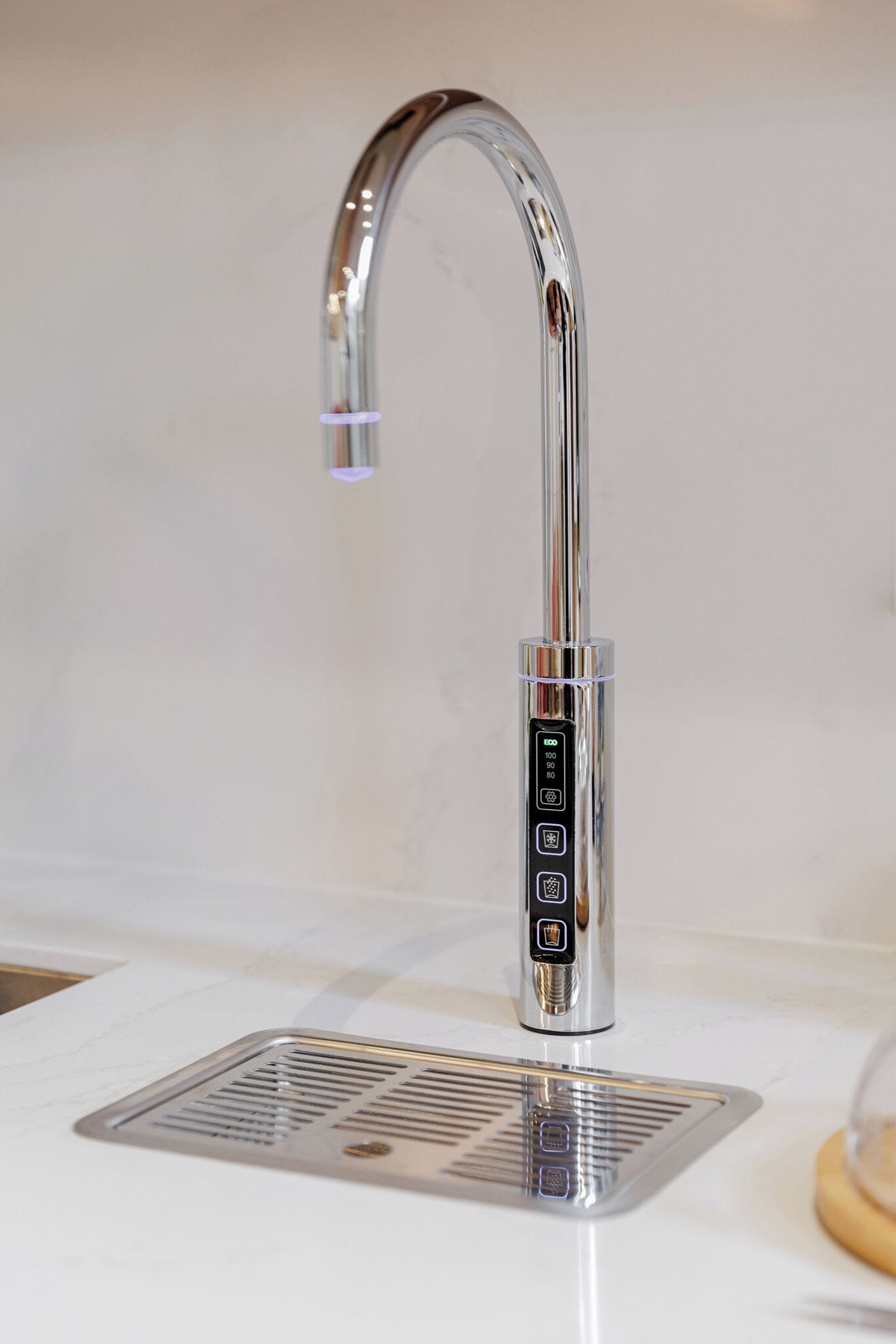 A modern kitchen with a stainless steel faucet, a built-in sink, and a visible control panel.