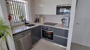 Uma cozinha moderna com eletrodomésticos de aço inoxidável, lava-louças e forno embutido.