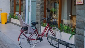 A hotel entrance with a sign reading "ALBA INN SANUR" and a sign that says "Lifes an Adventure Enjoy the Ride."
