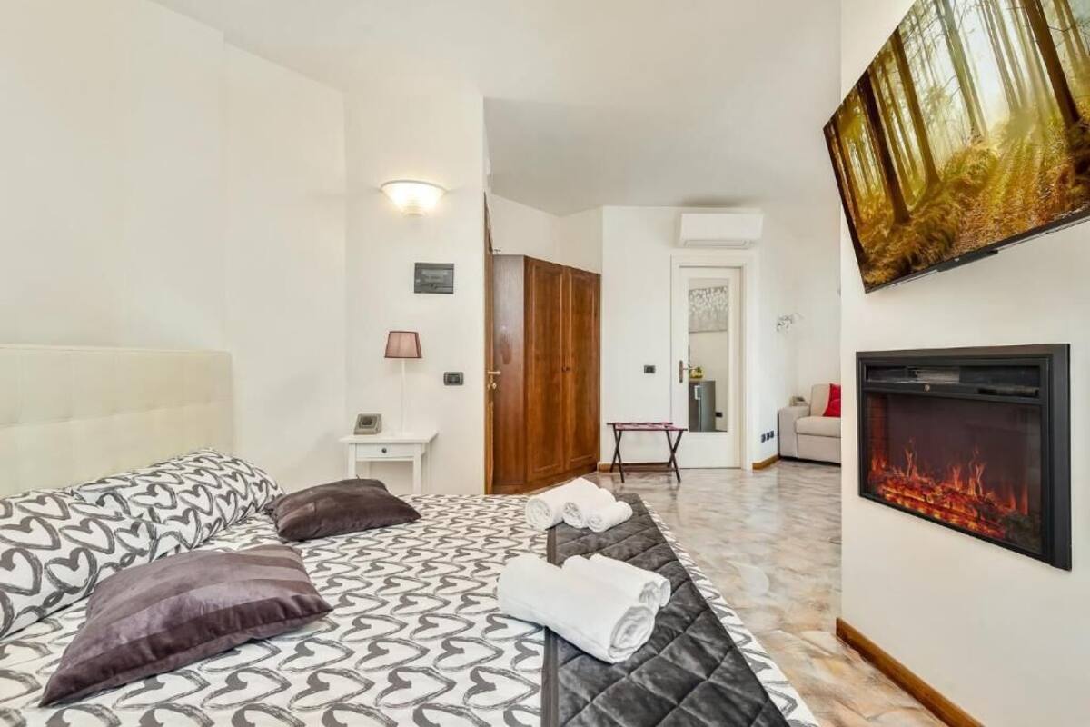 Une chambre d’hôtel avec un lit, une cheminée et un téléviseur.