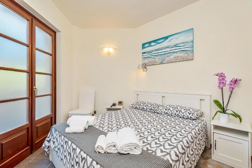 Une chambre d’hôtel avec un lit, une table de chevet, un tableau et une vue sur l’extérieur.