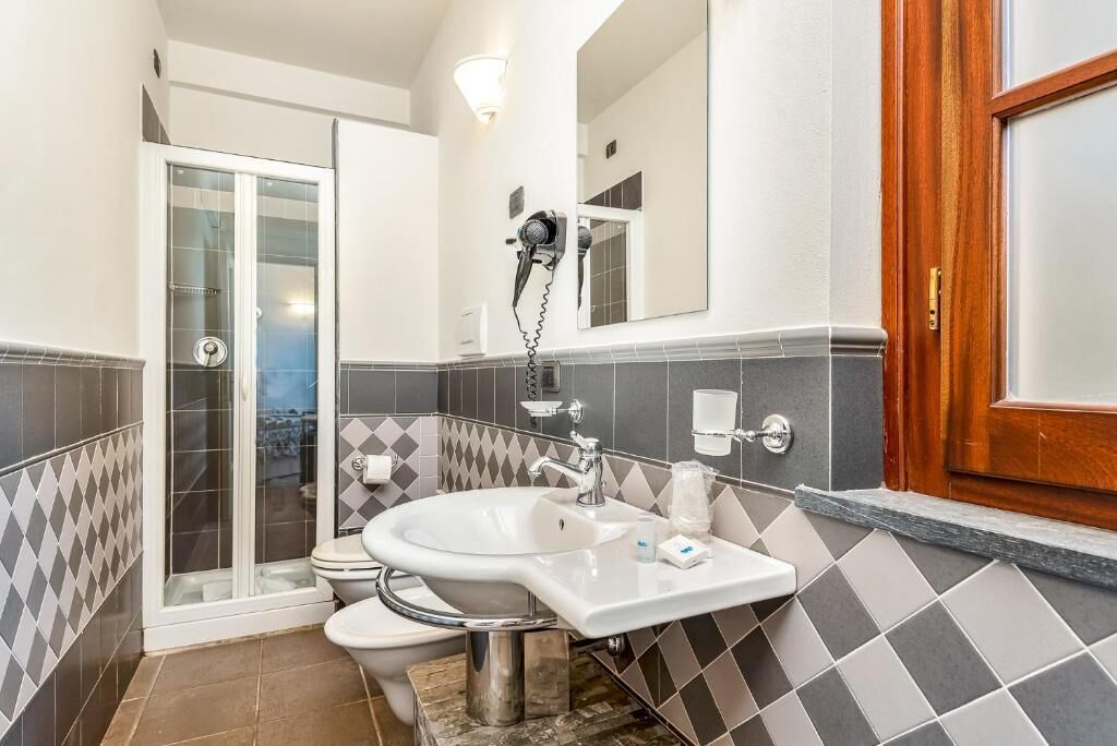 A bathroom with a shower, toilet, and sink.