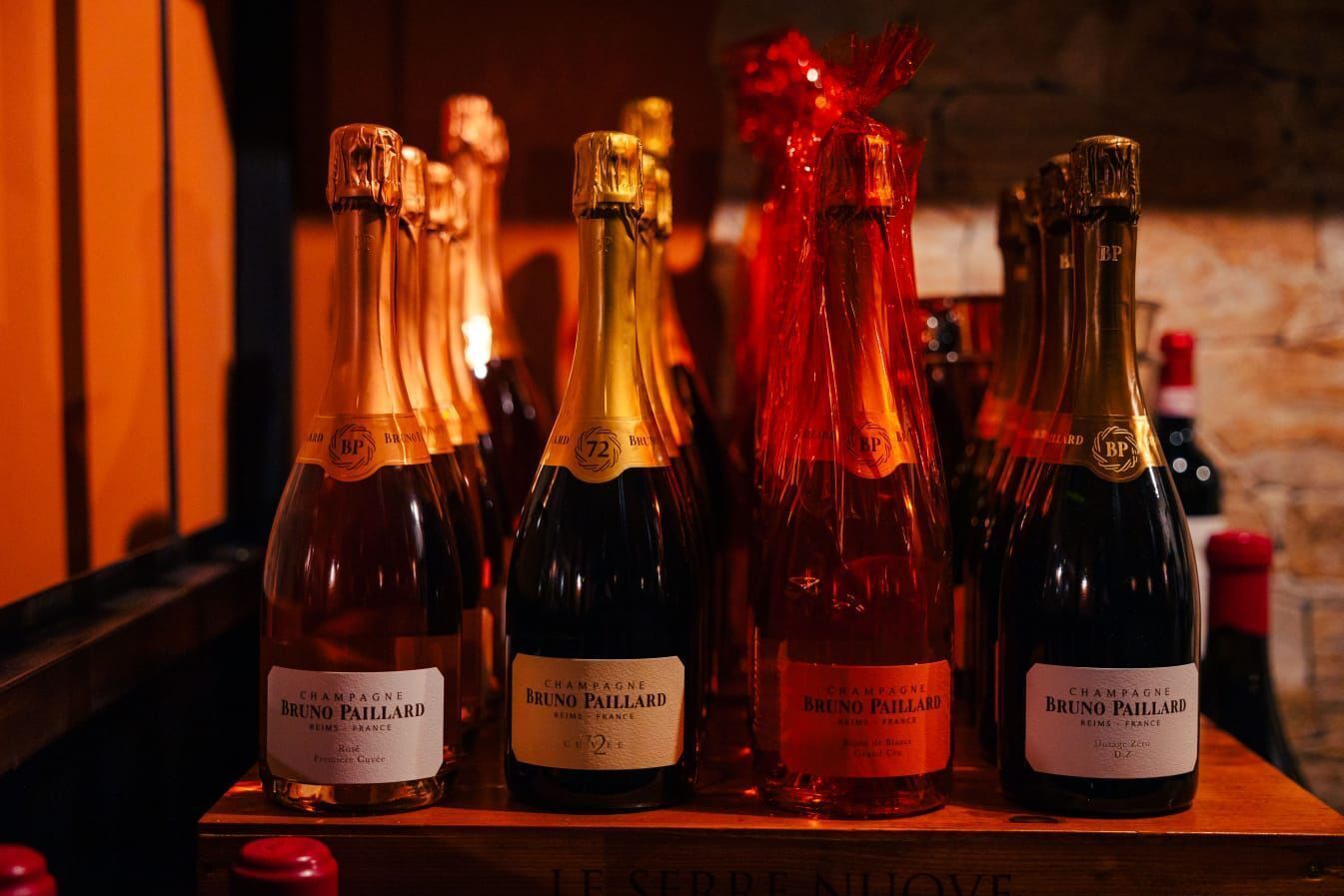 A selection of champagne bottles labeled Bruno Paillard on a wooden surface.