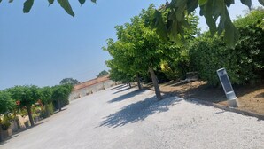 A gravel path leading to a building with a tiled roof, surrounded by trees and greenery. - Logis Hôtel le Clos Saint-Loup (Bram)