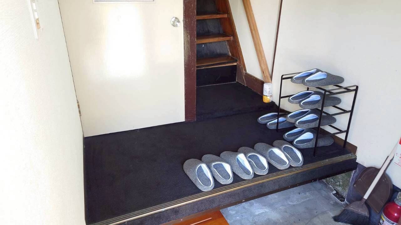 A staircase with a shoe rack on the landing.