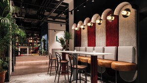 A modern interior with a seating area, a table, and chairs. - Ruby Bea Hotel Florence (Florence)