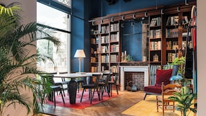 A cozy library with a fireplace, bookshelves, and comfortable seating. - Ruby Bea Hotel Florence (Florence)