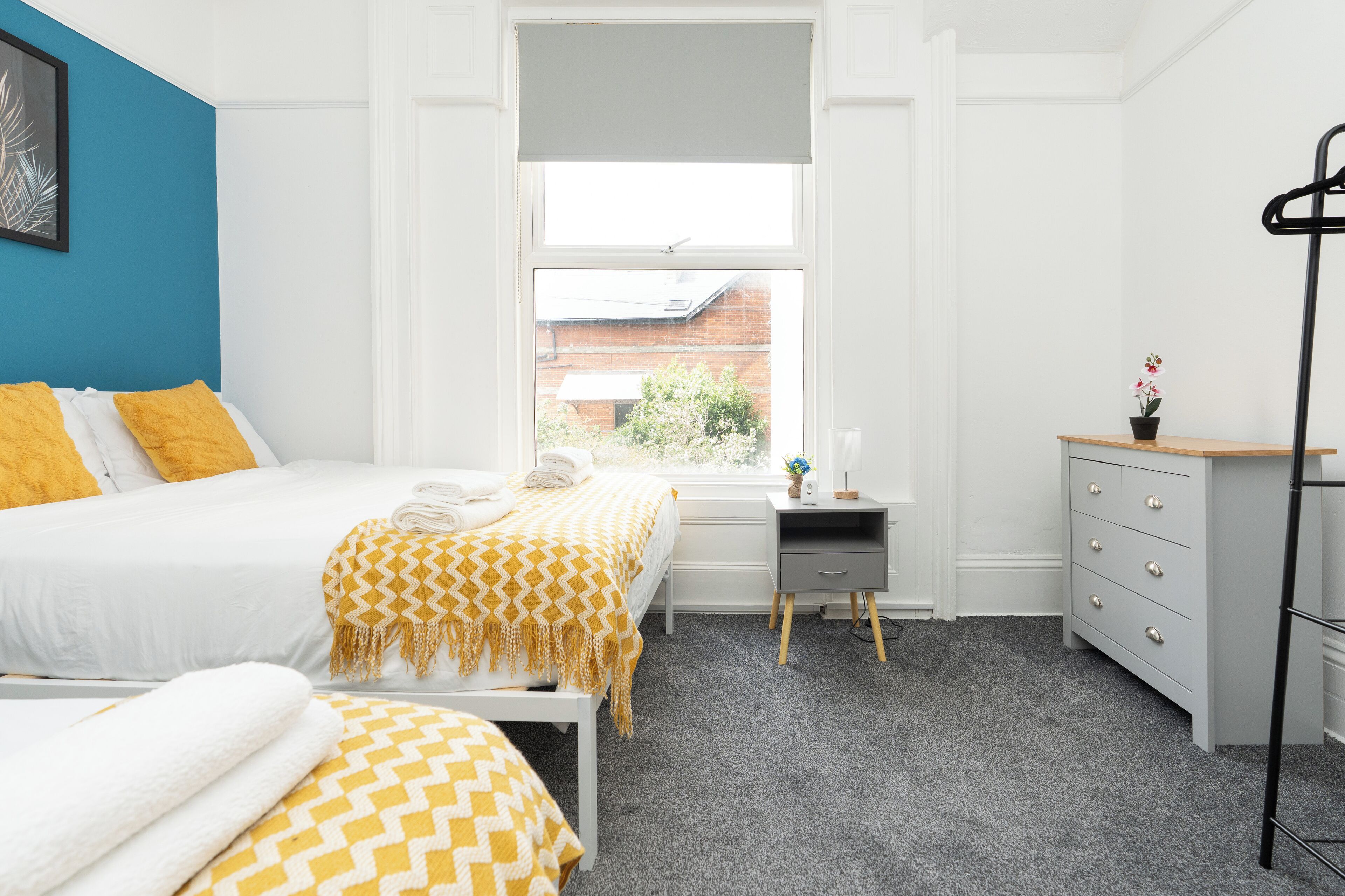 Une chambre à coucher avec un lit, une table de chevet et une commode.