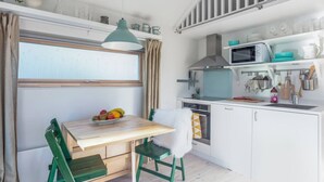 A compact kitchen with a dining area, a microwave, and a window.
