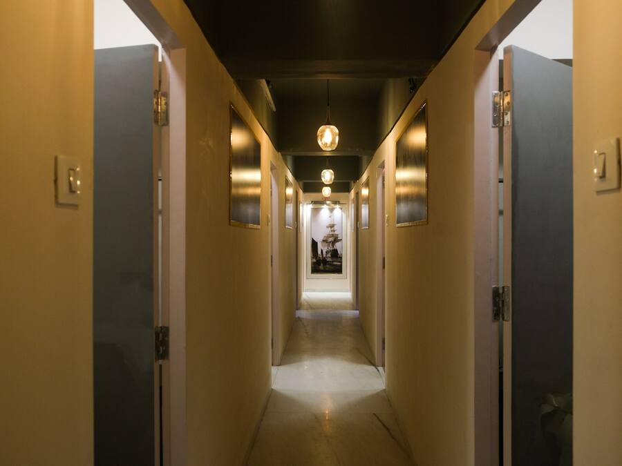 Un pasillo estrecho y bien iluminado, con puertas a ambos lados que dan a habitaciones.