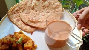 Une assiette de pains plats, une tasse de thé et un plat de légumes.