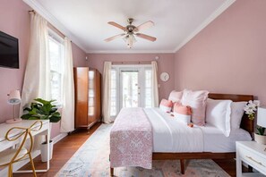 A bedroom with a bed, bedside table, desk, chair, and a ceiling fan. - Large Home w/ Back Yard Oasis | Perfect for Groups (New Orleans)
