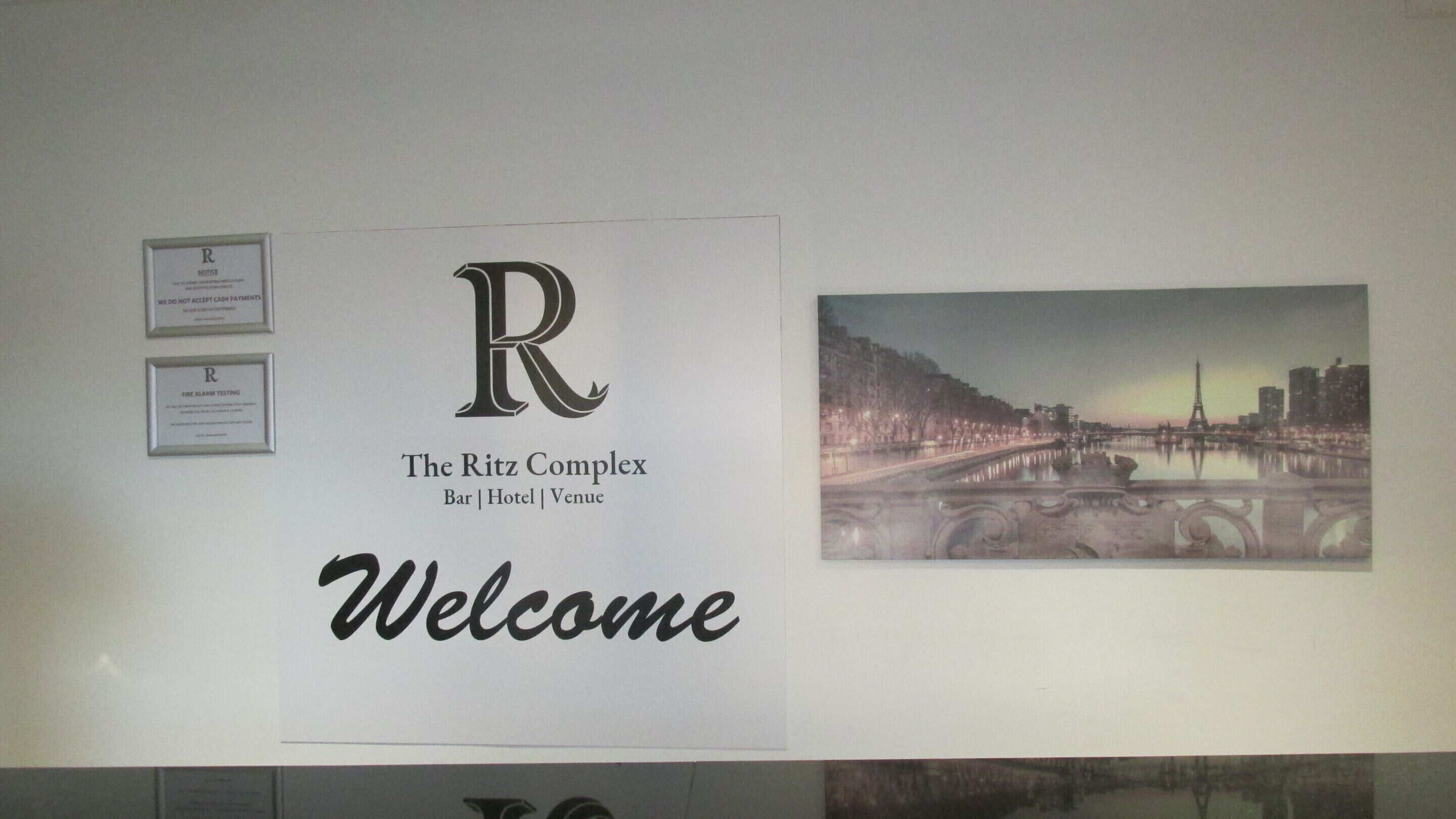 A welcome sign for The Ritz Complex with a cityscape view.