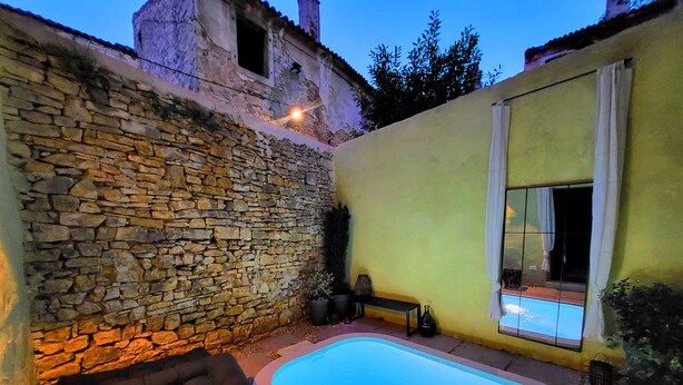 A stone wall, a pool, and a bench in a courtyard. - Casa Al Campanile for Your Relaxing Experience in a Rare Cocktail Pool (Vodnjan)