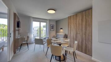 A modern dining area with a round table, chairs, and a sofa.