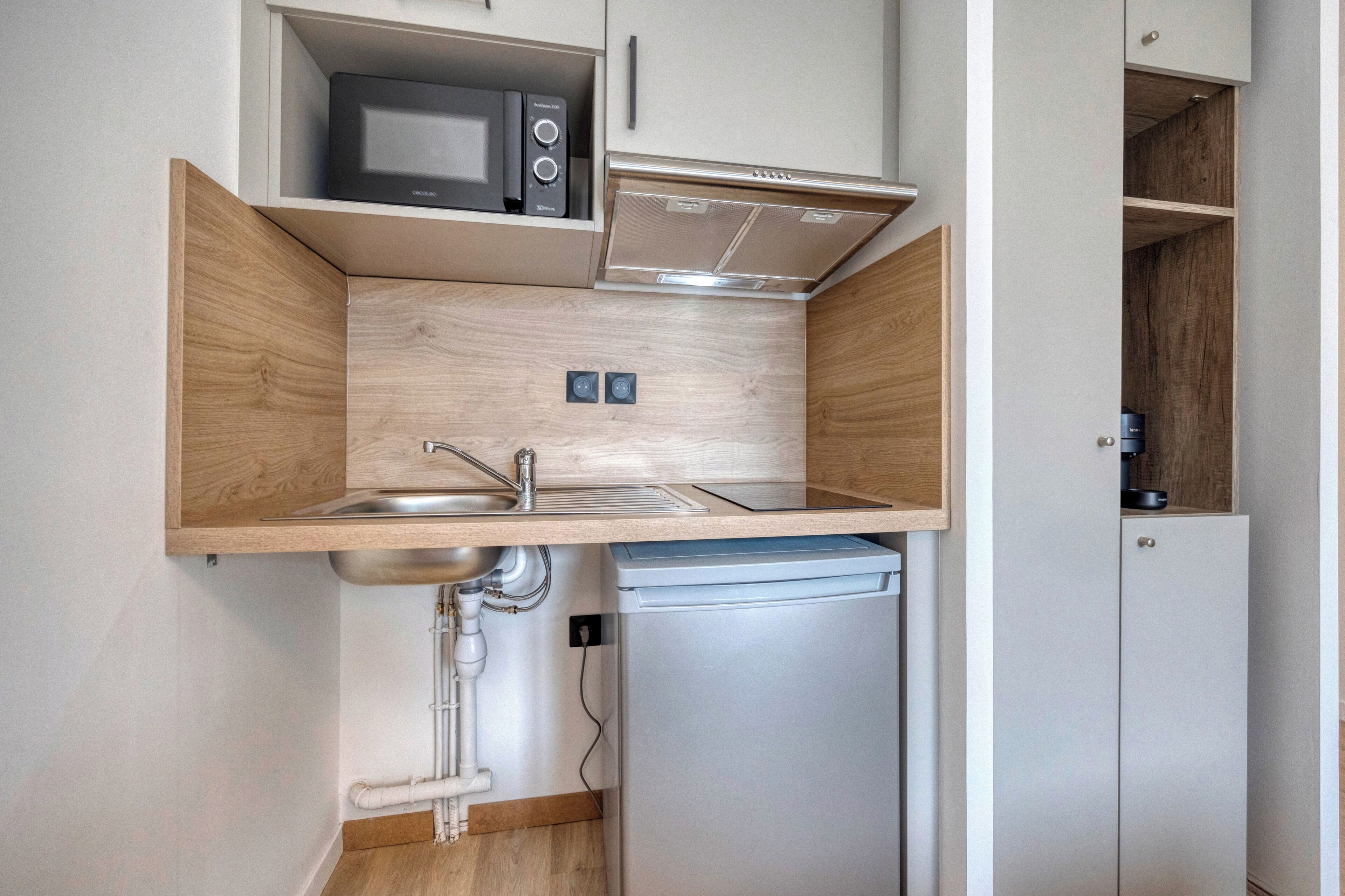 A compact kitchen with a microwave, stove, and dishwasher.