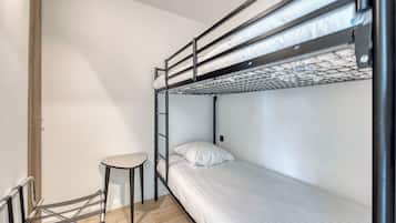 A bunk bed room with a small table and a ladder.