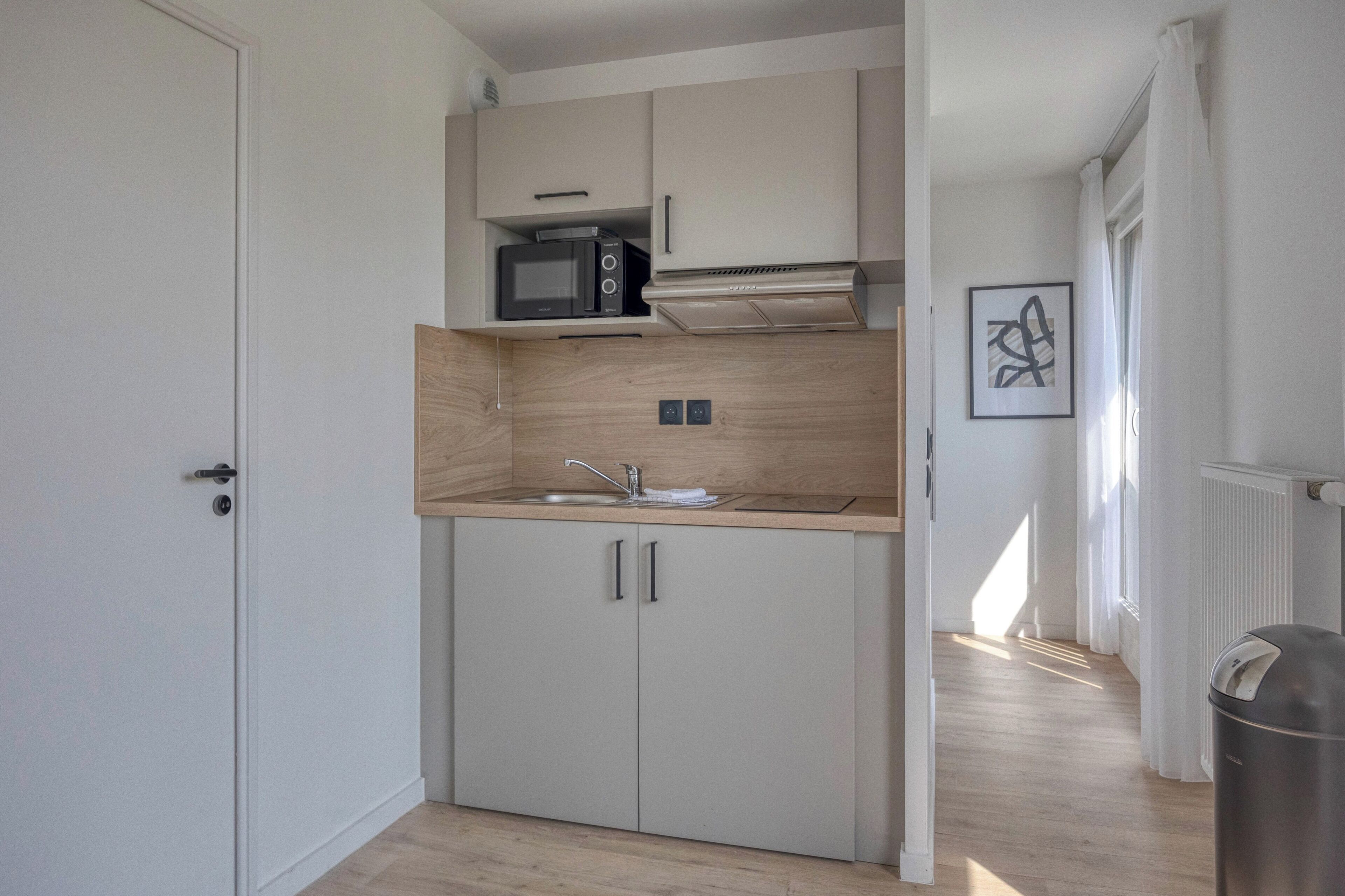 A compact kitchen with a microwave, stove, and sink.