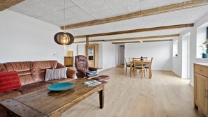 A spacious living area with a wooden coffee table, leather sofa, and a dining table with chairs. - Stunning home in Ribe with Wi-Fi (Ribe)