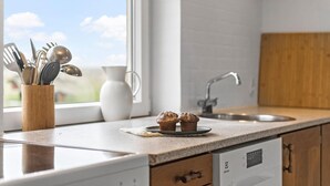 A kitchen with a wooden countertop, a sink, and a dishwasher. There are two muffins on a plate on the counter. - Stunning home in Ribe with Wi-Fi (Ribe)