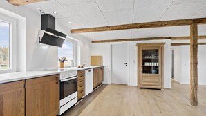 A modern kitchen with wooden cabinets, a built-in oven, and a large window. - Stunning home in Ribe with Wi-Fi (Ribe)