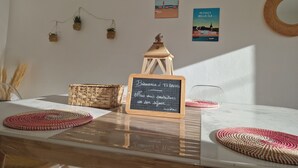 Un tavolo con tovagliette intrecciate, una lanterna e una lavagna.